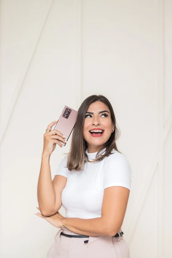 Lorena Moura segurando o celular, pronta pra fotografar